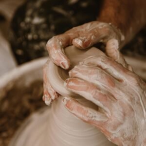 Artisan hands skillfully shaping wet clay on a pottery wheel, focusing on craftsmanship.