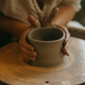 Hands shaping clay on a pottery wheel in a close-up shot, showcasing artistry.