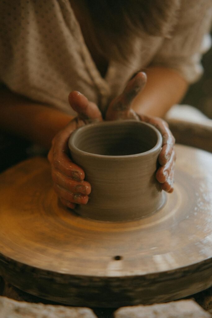 Hands shaping clay on a pottery wheel in a close-up shot, showcasing artistry.
